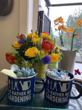 Load image into Gallery viewer, I'd Rather Be Gardening Mug Candles feature delightful garden themed wax inserts in blue and white mugs, perfect for decor